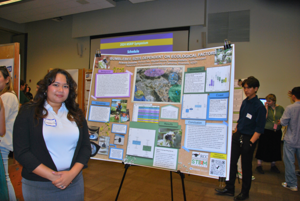 Student poses next to poster at 2024 MSRIP symposium