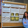 Student poses next to poster at 2024 Symposium