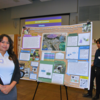 Student poses next to poster at 2024 Symposium